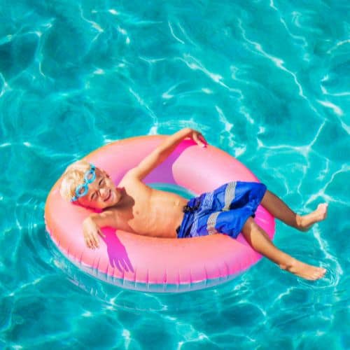 a young boy relaxes in the pool ar Dreams Huatulco, the best all-inclusive resort in Oaxaca for families!