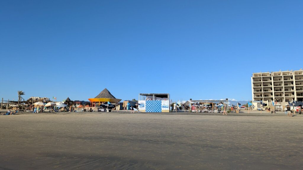 dozens of umbrellas of various colours line the beachfront at cerritos beach in Baja
